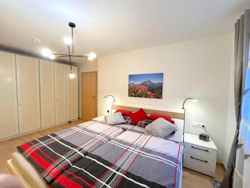 um quarto com uma cama grande e almofadas vermelhas em Ferienwohnung Bergnest em Bad Hindelang