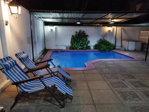 una piscina con 2 tumbonas junto a ella en Costanera Bed & Breakfast, en Santiago