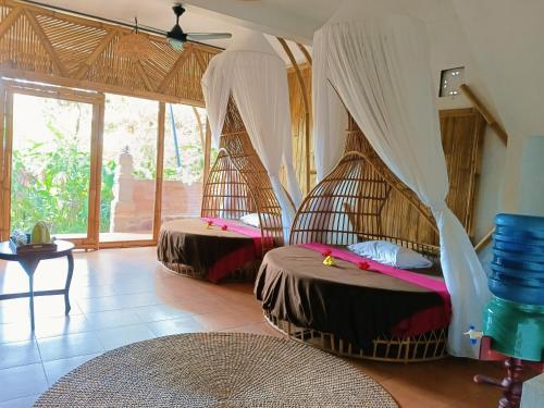 a room with two beds with mosquito nets in it at Great Mountain Views Villa Resort in Sidemen