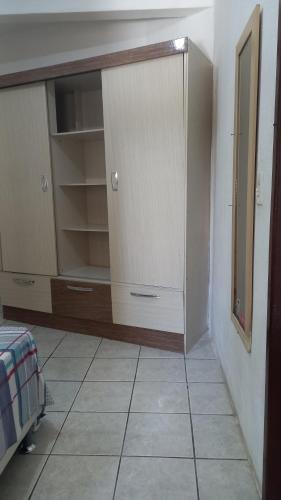 um quarto com um closet e piso em azulejo em Kit no Centrinho da Lagoa em Florianópolis