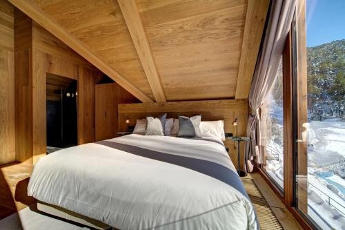 a large bed in a room with a large window at Chalet Enza Baqueira - By EMERALD STAY in Naut Aran