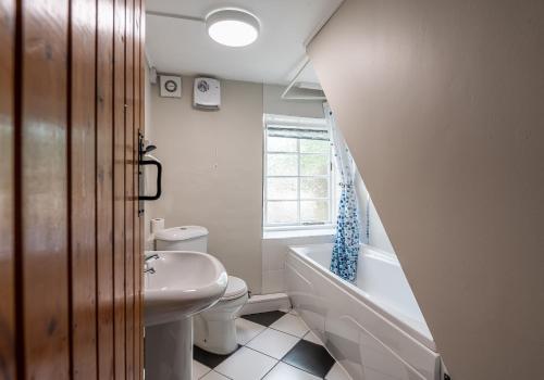 uma casa de banho com um lavatório, um WC e uma banheira em Hobsons Cottage em Grinton