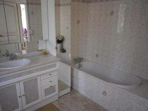 a bathroom with a tub and a sink and a bath tub at La Bastide Fleurie rez de piscine in Cavalaire-sur-Mer