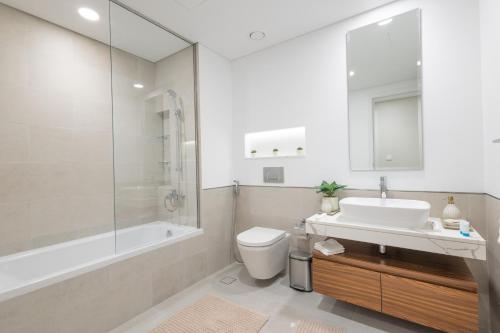 uma casa de banho com um lavatório, um WC e um chuveiro em SuperHost - Urban Elegance 2BR in Asayel 2 Near Burj Al Arab em Dubai