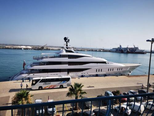a large yacht is docked in the water with a bus at DelleArtiGuesthouse Trapani Porto in Trapani