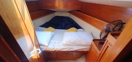 un petit lit au milieu d'un bateau dans l'établissement Coriandre 2 - Dormir sur un grand voilier 9 personnes By Nuits au Port, à La Rochelle