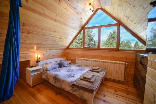 TornikにあるSrce Tornika, Tornik-Zlatiborの木造キャビン内のベッド1台が備わるベッドルーム1室を利用します。