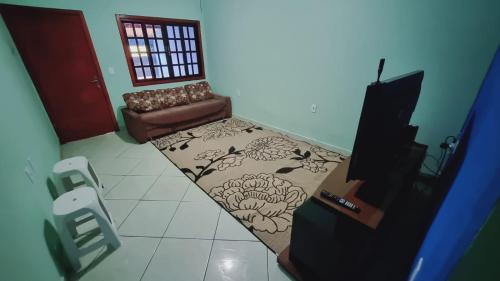 ein Wohnzimmer mit einem Sofa und einem Teppich in der Unterkunft Casa Confortável em Sumaré divisa Paulínia e Rod Anhanguera in Sumaré