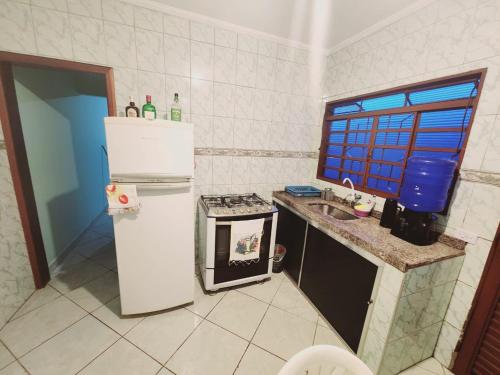 eine kleine Küche mit Kühlschrank und Spüle in der Unterkunft Casa Confortável em Sumaré divisa Paulínia e Rod Anhanguera in Sumaré