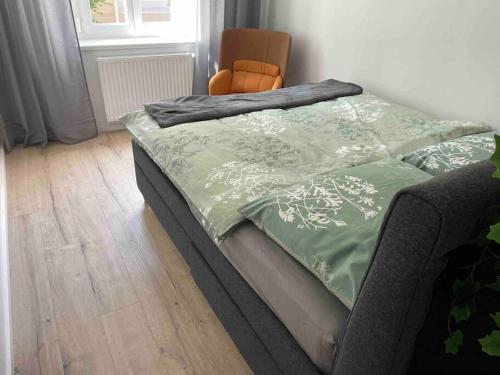 een bed met een groene dekbed en een stoel bij Studio Brunhilde - Messe Graz - 59 m² in Graz