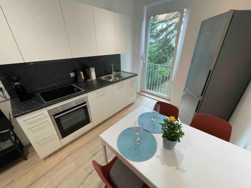 eine Küche mit einem Tisch mit 2 Stühlen und einem Kühlschrank in der Unterkunft Studio Brunhilde - Messe Graz - 59 m² in Graz