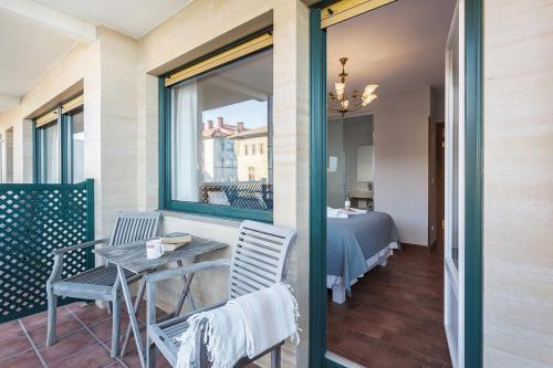 einen Balkon mit einem Tisch, Stühlen und einem Bett in der Unterkunft Pensión Zarauz Playa in Zarautz