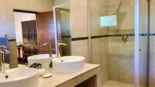 a bathroom with two sinks and a shower at Hill Top Villa - Private Room In A Home in Hazyview