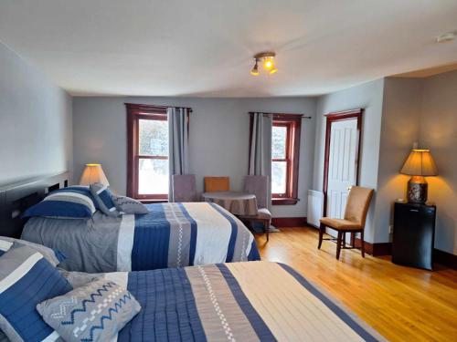 una habitación de hotel con 2 camas y una silla en Le 100 St-Laurent, en Louiseville
