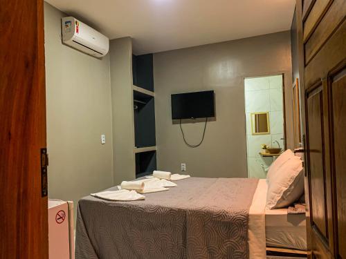 Zimmer mit einem Bett, einem TV und einem Spiegel in der Unterkunft Villa Paihia Jericoacoara in Jericoacoara