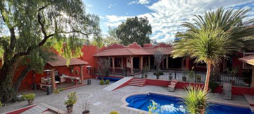 a red house with a swimming pool in front of it at LA CASA ROJA in Tequisquiapan