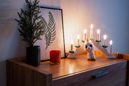 a dresser with candles and a stuffed animal on it at Pikk street Apartment in Tartu