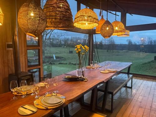 a long wooden table with glasses and flowers on it at Samadhi Eco Resort in Vilcún