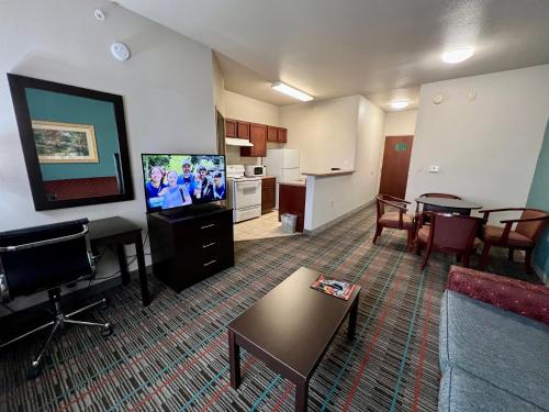 a living room with a couch and a tv and a kitchen at Quality Inn & Suites Near University in Waco