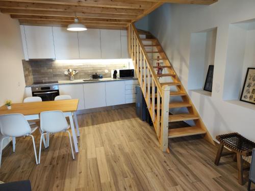 uma cozinha e sala de jantar com uma mesa de madeira e escadas em Casa Nº7 - Vila de Óbidos em Óbidos