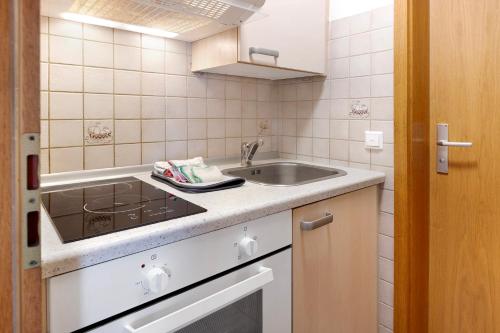 a small kitchen with a sink and a stove at Am Bächle in Lenzkirch