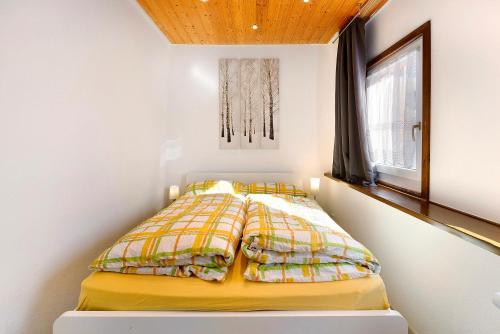 a bedroom with a bed with a yellow comforter at Am Bächle in Lenzkirch