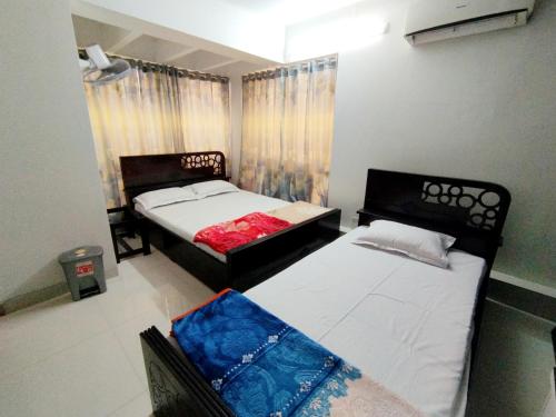 ダッカにあるHotel Labbaik Dhanmondiのベッドルーム1室(ベッド2台、窓付)