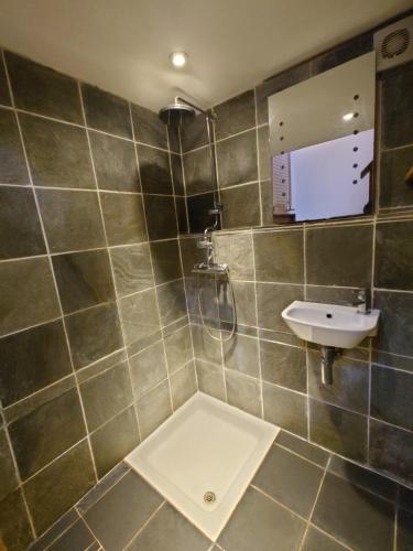 a bathroom with a shower and a sink at Fern Cottage Annexe in Croyde