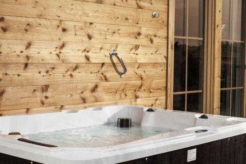 a bathtub in front of a wooden wall at Bayern Chalets in Ainring