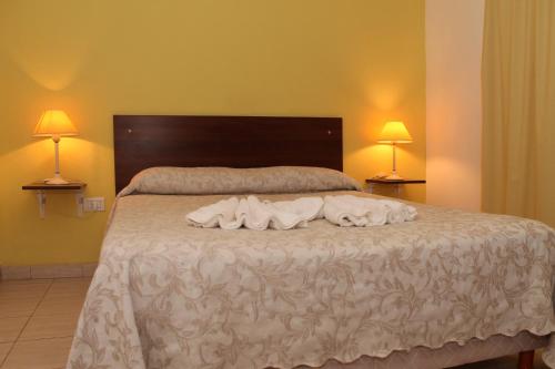 1 dormitorio con 1 cama con 2 toallas en Brisas del Lago Apartamentos en Colón