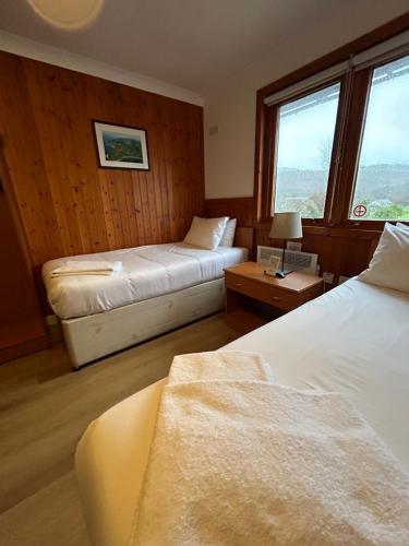 a hotel room with two beds and two windows at Roam West in Fort William