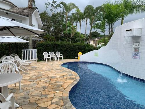 una piscina con un tobogán junto a una casa en Casa em Riviera de São Lourenço Prática e Confortável, Reformada e Equipada! en Bertioga