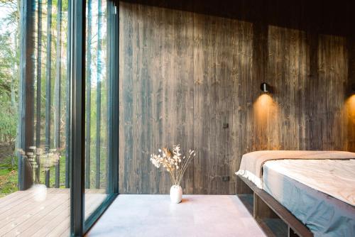 Hadsund的住宿－WoodHouse Denmark，一间卧室设有床和滑动玻璃门
