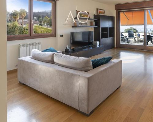 a large couch in a living room with a television at The House on the Lake in Reno Di Leggiuno