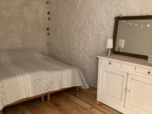 - une chambre avec un lit, un miroir et une commode dans l'établissement Loft au bord du Canal du Midi, à Roubia