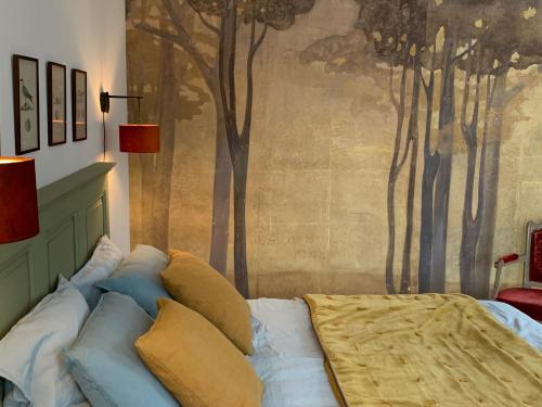 1 dormitorio con 1 cama con árboles en la pared en Chambre Suite d'hôte à Ouville la Rivière Normandie en Ouville-la-Rivière