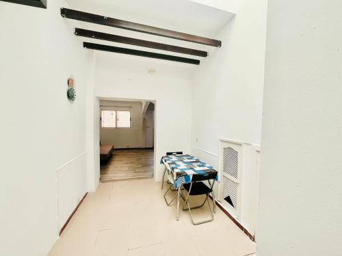 un comedor con una mesa en una habitación blanca en La Calzada Apartment, en Tafira