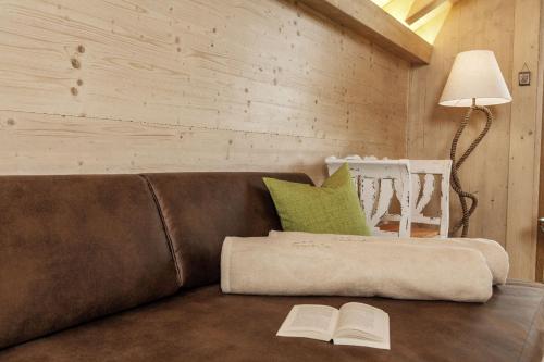 a brown couch with two books on a table at Bayern Chalets bei Salzburg und Berchtesgaden mit Whirlpool und Sauna in Ainring