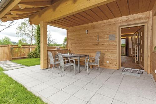 a patio with a table and chairs on it at Bayern Chalets bei Salzburg und Berchtesgaden mit Whirlpool und Sauna in Ainring