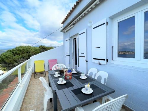un patio avec une table et des chaises sur un balcon dans l'établissement Appartement A Stagnola PORTICCIO, à Porticcio