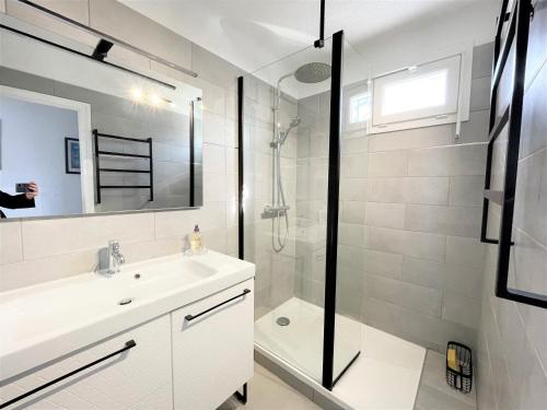 une salle de bain blanche avec une douche et un lavabo dans l'établissement Appartement A Stagnola PORTICCIO, à Porticcio