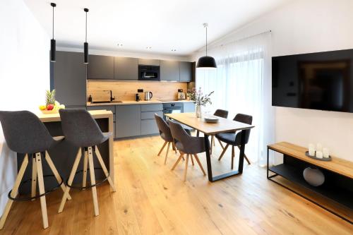 a kitchen and dining room with a table and chairs at Apartmány Horizont in Loučná pod Klínovcem