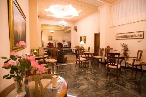 una sala de espera con mesas y sillas y un vestíbulo en Hotel Urania, en Preveza