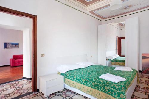 biała sypialnia z łóżkiem i czerwoną kanapą w obiekcie Casa Terrazzino Bianca w mieście Levanto