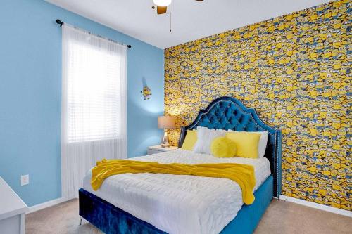 um quarto com uma cama azul e uma parede amarela em Villa Marshmallow em Kissimmee