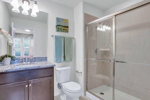 uma casa de banho com um chuveiro, um WC e um lavatório. em Villa Marshmallow em Kissimmee