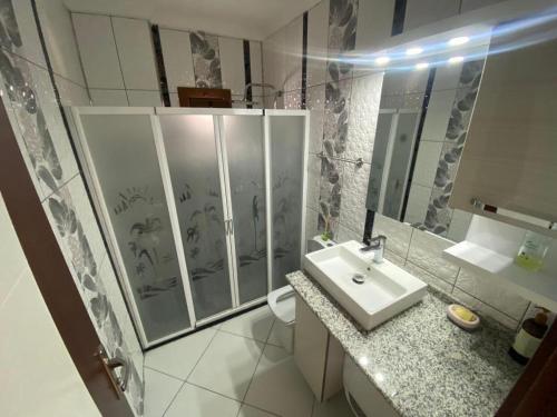 een witte badkamer met een wastafel en een douche bij Daire in Didim