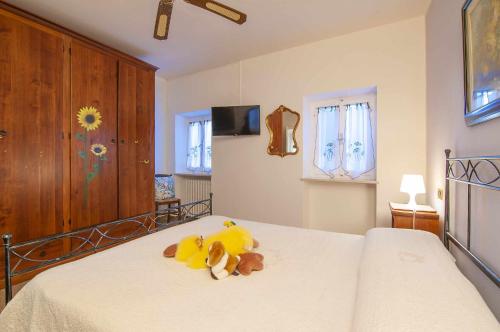 un dormitorio con una cama con un animal de peluche en Dimora Montelago Apartment Roby, en SantʼAmbrogio di Valpolicella