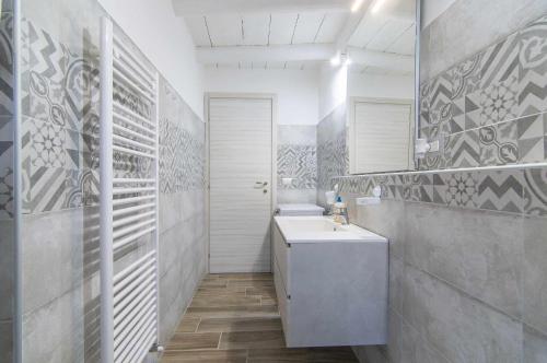 La salle de bains blanche est pourvue d'un lavabo et de toilettes. dans l'établissement Dimora Montelago Apartment Gino, à SantʼAmbrogio di Valpolicella