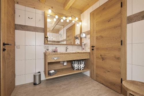 a bathroom with a sink and a mirror at Bayern Chalets bei Salzburg und Berchtesgaden mit Whirlpool und Sauna in Ainring